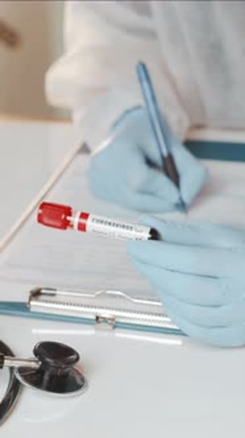 Medical Professional Holding Coronavirus Test Sample Writing Notes