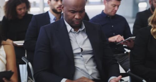 Businesspeople sitting in a convention center during a conference