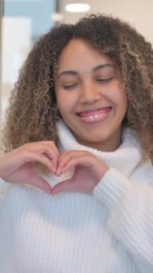 Smiling Woman Making Heart Shape with Her Hands