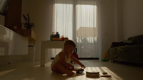 Baby plays with tambourine musical instrument at home