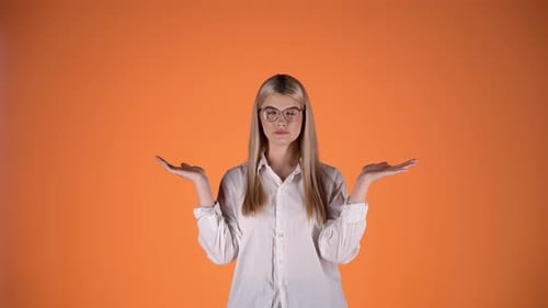 Blonde Girl Unsure Uncertain and Doubtful, Shrugging and Arms Hands Gesture, Colorful Studio Shot