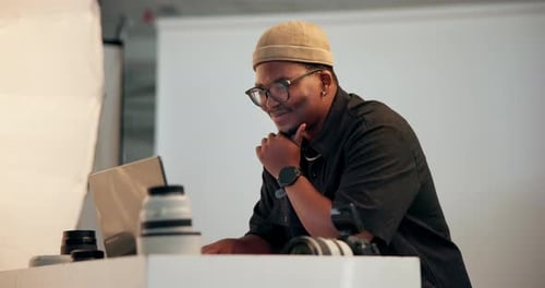 Photographer, man and thinking in studio with laptop, retouching image and creative idea