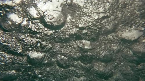 Bubbles rising underwater abstract background close up