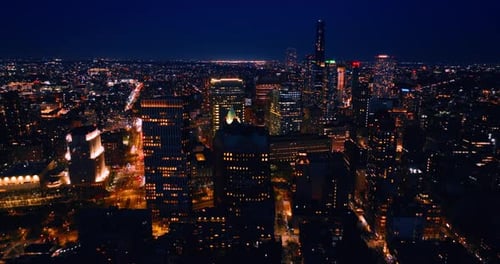 Brightly illuminated streets of New York, USA at night. Dazzling cityscape from aerial perspective.