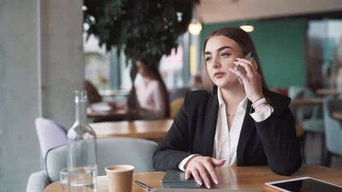 Young Woman Talking on Phone in Cafe