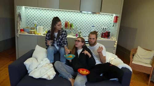 Enjoying a Casual Gathering on the Couch with Close Friends While Sharing Laughter Food and Fun