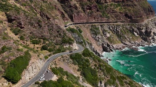 Wide angle aerial view of cars driving along a coastal road