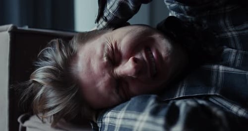 Distressed Person Lying on Couch Covering Face