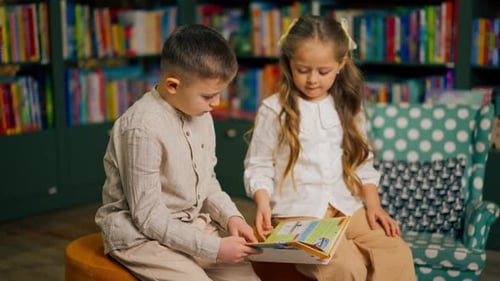 Close Up in Bookstore in the Children Area a Handsome Little Boy in Light Clothes and Girl Reads One