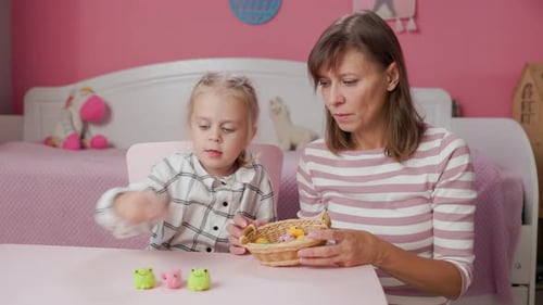 Child and Woman Playing with Knitted Animal Toys