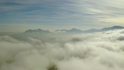 4k drone footage of clouds high above a mountainous area