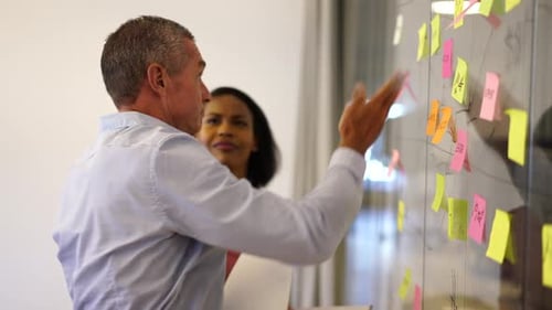 Diverse businesspeople high fiving after successful brainstorming session in modern office