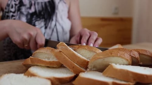 Woman Cuts Slices of Bread on Cutting Board
