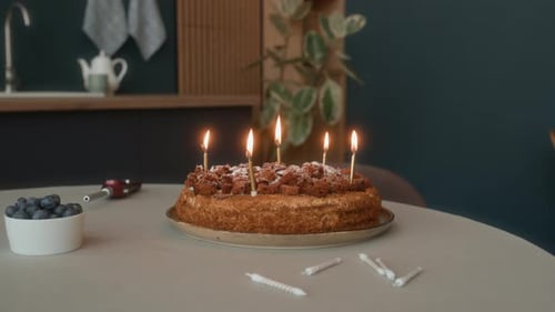 Candles Burning on Homemade Birthday Cake in Cozy Kitchen
