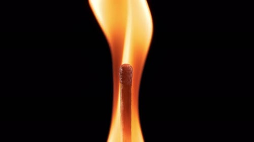 Burning Matchstick with Flickering Orange Flame on Black
