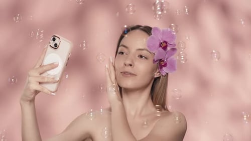 Woman Poses With Phone, Flowers and Bubbles
