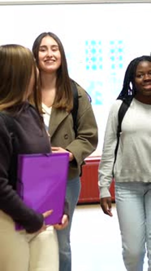 University Students Walking in Hallway with Backpacks and Smiles