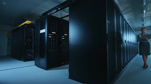 In Data Center Female IT Specialist Walks along the Row of Operational Server Racks, Checking Norma