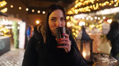 Profitez d'une boisson chaude sur le marché festif entouré de lumières et de joie des Fêtes pour créer une ambiance parfaite