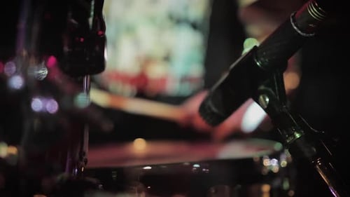 A close up of a drummer preparing to perform live on stage.