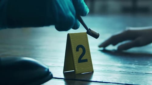 Gloved Hand Placing Bullet Casing Near Crime Scene