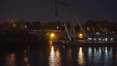 View from boat sailing at night in the river along the city with beautiful reflections of city light