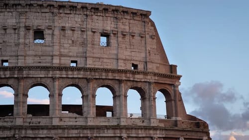 Medium shot outside view of the Colosseum at sunset, Rome, Italy.
