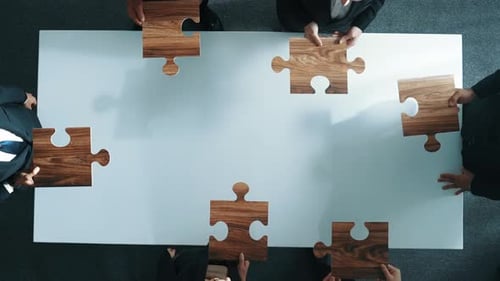 Team Building Concept: Business People Solving Jigsaw Puzzle