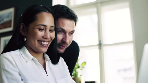 Smiling Woman and Man Looking at Laptop Screen