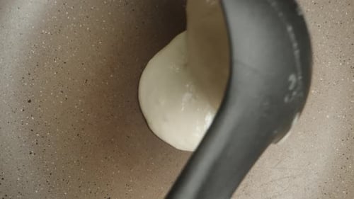 I pour the pancake batter into the pan, top view, close-up, slow motion