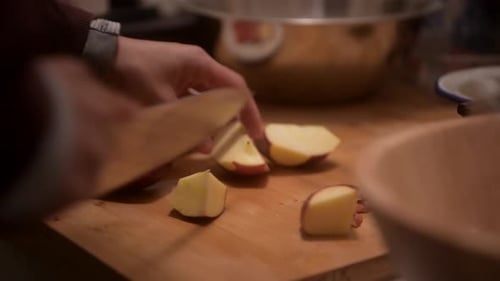 Chopping Apples with Knife on Wooden Cutting Board