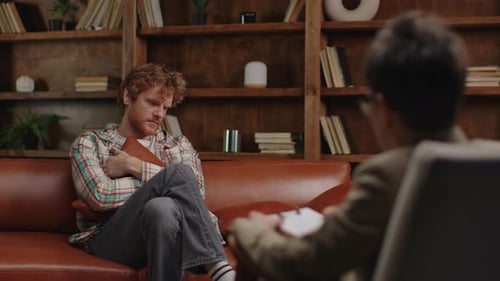 Young Man Talking to Therapist on Couch
