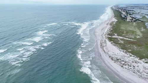 Aerial View of Ocean Waves Crashing on Sandy Shoreline