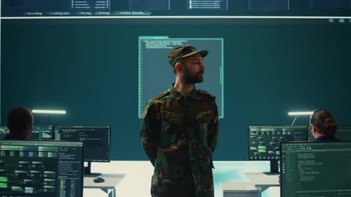 Man in Camouflage Oversees Coders in Modern Office
