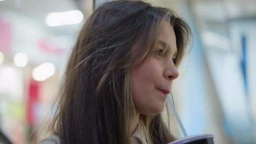 Close Up Woman Sipping Drink With Straw Indoors