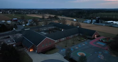 Bâtiment scolaire américain la nuit. Terrain de jeu de récréation élémentaire dans des conditions de faible luminosité. Vue aérienne.