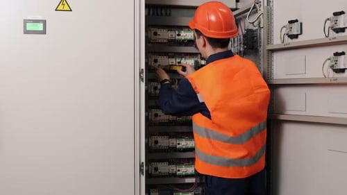 Electrician Inspecting Electrical Panel in Bright Room