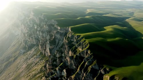 A Verdant Highland Shrouded in Mist with a Rugged Cliff Jutting Out of the Grassy Terrain Open Sky