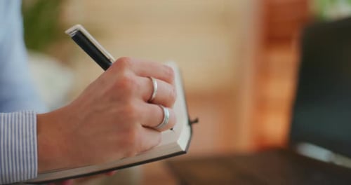 Hand Writing in Notebook at Office Desk