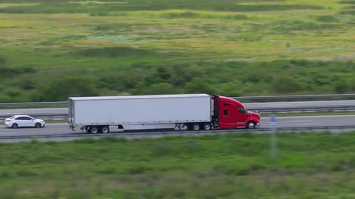 Aerial View of Semitruck Driving on Busy American Interstate Freeway Delivering Cargo Concept