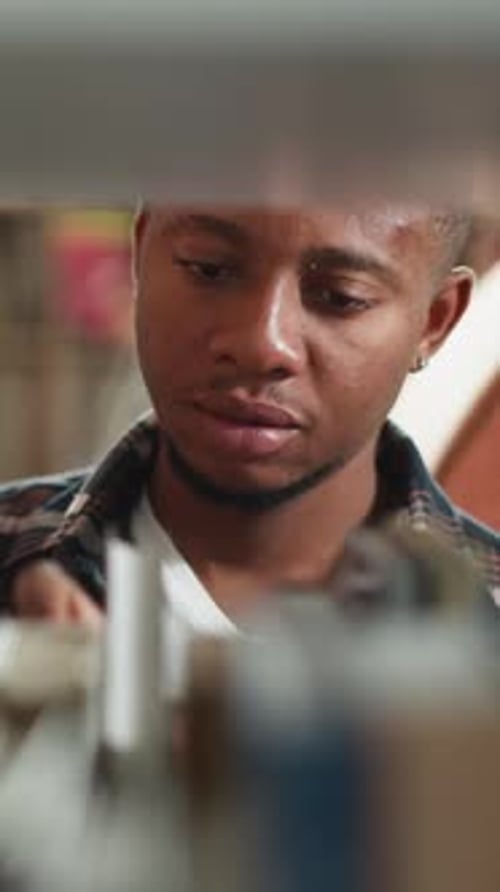 Black Guy Looks for Book on Shelf Closeup