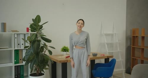Young Woman Standing Smiling in Indoor Home Setting