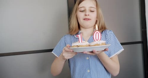 Girl Celebrating Tenth Birthday Blowing Out Candles