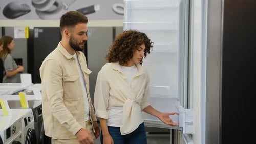 Newlyweds Couple Choosing Discount Refrigerator in Appliance Store