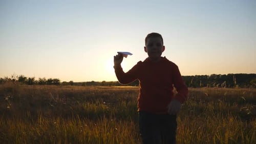 Carefree Small Boy Jogging with a Paper Airplane Through Meadow Cute Little Child Running Along