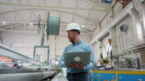 Chefingenieur mit Laptop im Werk analysiert den Produktionsprozess