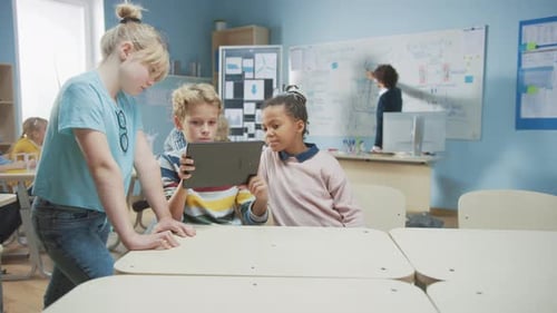 Elementary School Computer Science Class: Two Girls and Boy Use Digital Tablet Computer with Augmen
