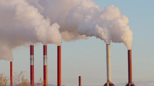 Schornsteine der Industriefabrik, in denen starker Rauch mit Himmelshintergrund aufsteigt, statische Aufnahme
