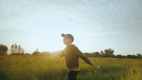 A criança corre pela grama com os braços levantados como um avião