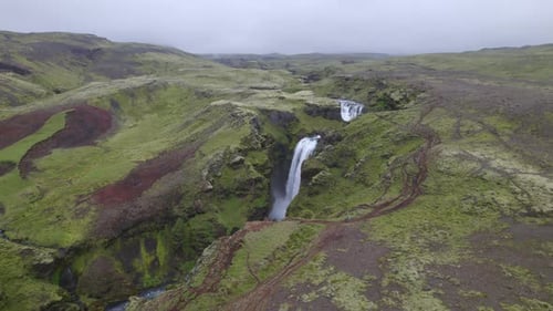 Aerial over the famous natural landmark and tourist attraction of Skogafoss falls in Iceland. Drone